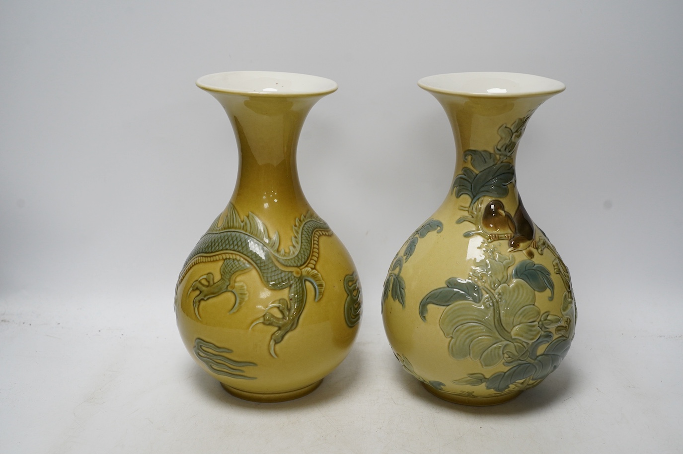 Two Lladro vases decorated in relief with dragons and birds, 26cm high. Condition - good